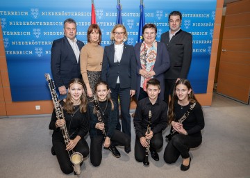 Im Bild v. l. n. r.: Bürgermeister Friedrich Pallinger, Elisabeth Haberhauer (Geschäftsführerin NÖBV), Landeshauptfrau Johanna Mikl-Leitner, LAbg. Michaela Hinterholzer, Bernhard Thain (Landesobmann NÖBV) mit jungen Blasmusiktalenten.