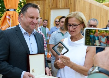 Geschäftsführer Christian Lang und Landeshauptfrau Johanna Mikl-Leitner mit dem Zahn eines Ur-Hais, der mehrere Millionen Jahre alt ist.