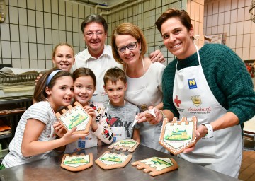 Josef Schmoll (Präsident Rotes Kreuz NÖ), Familien-Landesrätin Christiane Teschl-Hofmeister und Ex-Skirennläuferin Michi Dorfmeister mit Kindern in der Backstube der Bäckerei Schmidl in Dürnstein