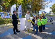 Landesrat Ludwig Schleritzko, Landeshauptfrau Johanna Mikl-Leitner und Radland-Geschäftsführerin Susanna Hauptmann mit Kindern und der gelben ÖAMTC-„Spazierraupe“.