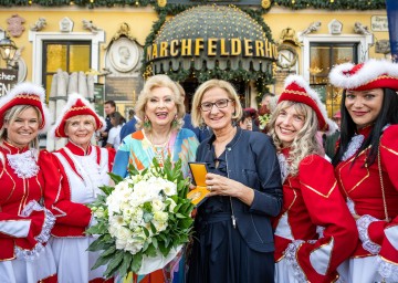Landeshauptfrau Johanna Mikl-Leitner und Jubilarin Birgit Sarata mit der Damengarde Deutsch-Wagram bei der Überreichung der „Goldenen Ehrenplakette“ im Rahmen des Geburtstagsfestes vor dem Marchfelderhof.