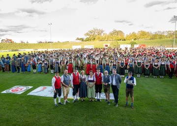 Landeshauptfrau Johanna Mikl-Leitner mit Bürgermeisterin Michaela Hinterholzer (5. von rechts), Bürgermeister Christian Haberhauer (2. von links) sowie mehr als 700 Musikantinnen und Musikanten am Fußballplatz in Mauer.