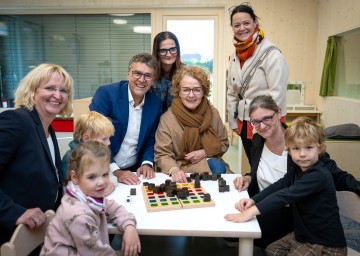 Kindergartenleiterin Birgit Holzbauer, Bürgermeister Christian Flammer, Manuela Cap, Familien-Landesrätin Christiane Teschl-Hofmeister, Astrid Göschl und Verena Kaltenegger mit Isabell, Elias und Joel (v.l.n.r.).