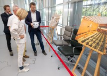 Landtagsdirektor Thomas Obernosterer, Landtagspräsident Karl Wilfing, Landeshauptfrau Johanna Mikl-Leitner und Abteilungsleiter Christoph Reiter (v.l.n.r.) vor den Abgeordnetensesseln, die generalüberholt werden. 