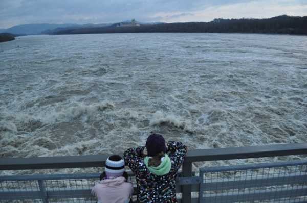 Zwei Kinder blicken in die hochwasserführende Donau beim Kraftwerk Melk