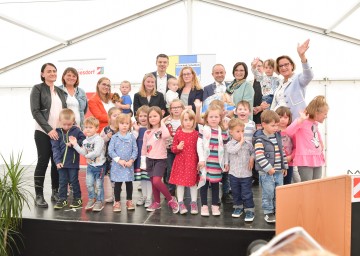 Von rechts nach links: Landeshauptfrau Johanna Mikl-Leitner, Pfarrer Zenon Pajak, Kindergartenleiterin Daniela Schmidt, Bürgermeister Walter Handl (Schollach), Kindergartenpädagogin und Bürgermeister Thomas Vasku (Loosdorf) mit Kindergartenkindern und weiteren Pädagoginnen