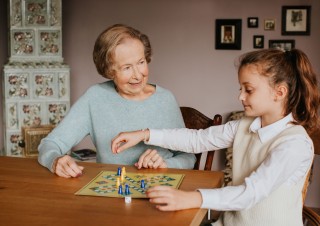 Großmutter und Enkelin spielen Mensch ärgere dich nicht.