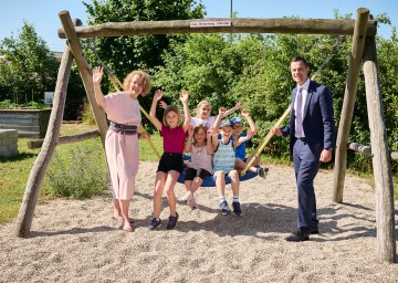 Landesrätin Christiane Teschl-Hofmeister und Bildungsdirektor Karl Fritthum freuen sich mit Schülerinnen und Schülern der ÖKO-Mittelschule Pottenbrunn auf den bevorstehenden Ferienbeginn.