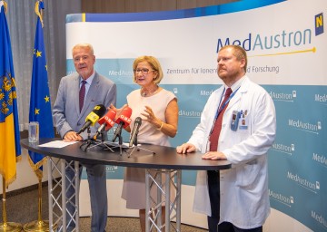 Neue Bestrahlung mit Kohlenstoffionen am MedAustron Wiener Neustadt: Im Bild Landeshauptfrau Johanna Mikl-Leitner, flankiert von MedAustron-Aufsichtsratsvorsitzendem Klaus Schneeberger (links) und Piero Fossati, dem wissenschaftlichen und klinischen Direktor der Kohlenstoffionen-Behandlung.