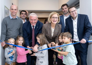 Kindergartenzubau in Stetten offiziell eröffnet: Gemeinderat Michael Wiedeck, Abgeordneter Christian Gepp, LH-Stellvertreter Franz Schnabl, Landeshauptfrau Johanna Mikl-Leitner, Vizebürgermeister Michael Mader und Bürgermeister Thomas Windsor-Seifert (v.l.n.r.) mit Kindergartenkindern 