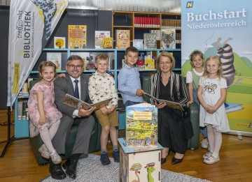 LR Ludwig Schleritzko und LR Christiane Teschl-Hofmeister im Kreise der ersten Kinder, die das neue Wimmelbuch „Mein großes Niederösterreich“ durchblättern durften.