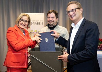 Landeshauptfrau Johanna Mikl-Leitner, Vizebürgermeister Johannes Maschl und Bürgermeister Georg Ockermüller bei der Befüllung der Zeitkapsel mit amtlichen Gründungsdokumenten. 