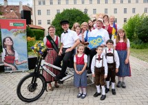 Landeshauptfrau Johanna Mikl-Leitner freut sich über einen besonderen Transport zur Bühne am Rathausplatz in bunter Begleitung vieler Niederösterreicherinnen und Niedersöterreicher.