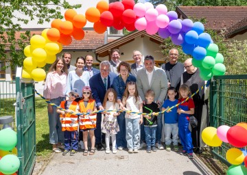 (v.l.n.r.): Kindergartenleiterin Stephanie Schwarz, Geschäftsführender Gemeinderat Thomas Kropik, Barbara Lampl, Bürgermeister Johannes Grasel (Gemeinde Heiligenkreuz), Landtagsabgeordneter Christoph Kainz, Bezirkshauptmann Christian Pehofer, Familien-Landesrätin Christiane Teschl-Hofmeister, Vizebürgermeister Gregor Burger, Bürgermeister Stefan Loidl, Pater Sebastian und Pater Ägydius mit Paul, Mia, Melania, Magdalena, Paul, Florian und Hanna.
