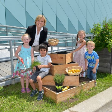 Landesrätin Mag. Barbara Schwarz freut sich gemeinsam mit den Kindergartenkindern über die reiche Ernte der Erdäpfelpyramide.