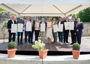 Gruppenfoto nach der Urkundenüberreichung (v.l.n.r.): Franz Heisler (Pöchlarn), Gerhard Bauer (Zwentendorf), Dominik Hagmann (Traismauer), Bernd von Droste zu Hülshoff, Ruth Pröckl, Hans Wallowitsch (Bad Deutsch Altenburg), Landeshauptfrau Johanna Mikl-Leitner, Martin Pircher (Zeiselmauer-Wolfpassing), Franz Xaver Hebenstreit (Tulln), Eduard Pollhammer (wissenschaftlicher Leiter Römerstadt Carnuntum), Martin Almstädter (Petronell-Carnuntum), Johann Bachinger (Wallsee-Sindelburg) und Klubobmann August Wöginger.