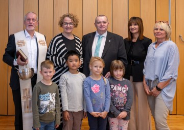 Foto (v.l.n.r.): Dechant Ernst Steindl, Familien-Landesrätin Christiane Teschl-Hofmeister, Bürgermeister Heinrich Becker, Kindergarteninspektorin Elisabeth Heiß und die stellvertretende Kindergartenleiterin Brigitte Jancic mit Jannik, Phabum, Miria und Bibiane