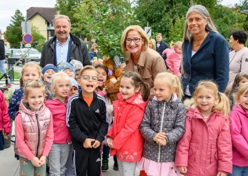 Bürgermeister Johann Rädler, Landeshauptfrau Johanna Mikl-Leitner, Leiterin Sabina Doria (v.i.n.r.) und die Kinder von Bad Erlach freuen sich über den neuen Landeskindergarten.