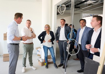 ecoplus Digital Geschäftsführer Lukas Reutterer führt Landtagsabgeordneten Christoph Kaufmann, Landeshauptfrau Johanna Mikl-Leitner, Landesrat Jochen Danninger, Stadtrat Lucas Sobotka und Landtagsabgeordneten Bernhard Heinrichsberger durch die Großbaustelle im „Haus der Digitalisierung“.