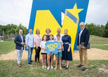 Regionsobmann Franz Aigner, Abgeordneter zum NÖ Landtag Bernhard Heinreichsberger, Geschäftsführende Gemeinderätin Elisabeth Hofbauer, Familien-Landesrätin Christiane Teschl-Hofmeister, Geschäftsführender Gemeinderat Franz Nefischer, Familienministerin Susanne Raab und Vizebürgermeister der Marktgemeinde Absdorf Leopold Weinlinger mit Olivia, Amelie und Paul vor dem „Unser N“ auf dem Spielplatz in Absdorf.