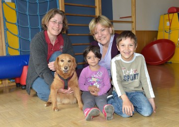 Tiergestützte Pädagogik: Hundetrainerin Michaela Frassine, Therapie-Hund Hugo, Landesrätin Mag. Barbara Schwarz mit Kindern im Kindergarten Zinzendorf. (v.l.n.r.)