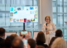 Landeshauptfrau Johanna Mikl-Leitner bei ihrer Festansprache mit den ausgezeichneten Werken im Hintergrund.