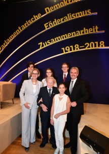 Generationenübergreifende Gestaltung der Gedenkveranstaltung: Landeshauptfrau Johanna Mikl-Leitner und Landtagspräsident Karl Wilfing mit dem 106-jährigen Zeitzeugen Otto Filipsky, der jungen Sängerin Larissa Höfler und den drei Schülern Hannah Harkess, Aron Bachmann und Paul Müller.