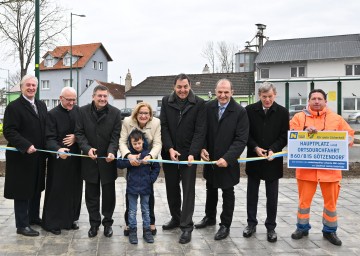 (v.l.n.r.) Landtagsabgeordneter Gerhard Schödinger, Pfarrer Andreas Michalski, Bürgermeister Kurt Wimmer, Landeshauptfrau Johanna Mikl-Leitner mit Helfer Pauli, NÖ Straßenbaudirektor Josef Decker, Bundesratsabgeordneter Otto Auer, Bezirkshauptmann Peter Suchanek und Hermann Binly von der Straßenmeisterei Bruck a. d. Leitha geben mit dem Durchschneiden des Bandes den neuen Hauptplatz und die neue Ortsdurchfahrt offiziell frei.