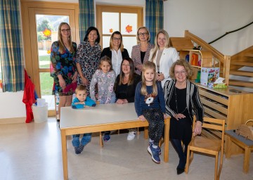 (v.l.n.r.) Kindergartenleiterin Stellvertreterin Claudia Redlberger, Kindergarteninspektorin Gabriele Holzer, Leiterin der Tagesbetreuungseinrichtung Renate Schauer, Bürgermeisterin Ramona Fletzberger, Bezirkshauptfrau Daniela Obleser, Landtagsabgeordnete Silke Dammerer und Landesrätin Christiane Teschl-Hofmeister mit den Kindern Matthias, Elena und Sarah. 