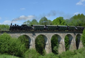 Eine Dampflokomotive zieht alte Personenwaggons