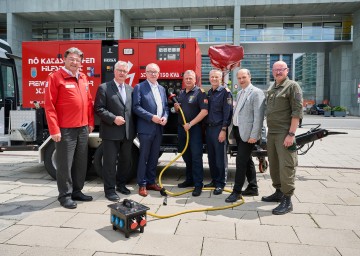 (v.l.n.r.) Der Präsident des Roten Kreuzes Josef Schmoll, Zivilschutzverband Präsident Christoph Kainz, LH-Stellvertreter Stephan Pernkopf, Landesfeuerwehrkommandant Dietmar Fahrafellner, Landespolizeidirektor Franz Popp, Gemeindebund Präsident Johannes Pressl und Militärkommandant Martin Jawurek vor einem Notstromaggregat der Feuerwehr.