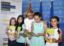 Landeshauptfrau Johanna Mikl-Leitner mit Malika, Samira, Ivona und Rüya aus der Daniel Gran Volksschule in St. Pölten beim Schmökern in der  neuesten Ausgabe des Kinderschaufensters.